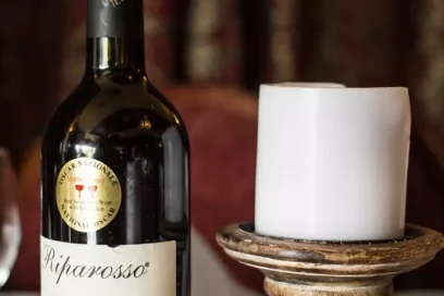 Red wine bottle beside a candle